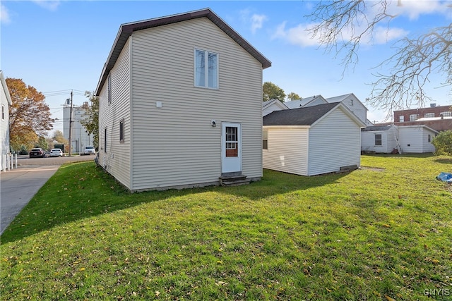 back of house featuring a yard and a shed