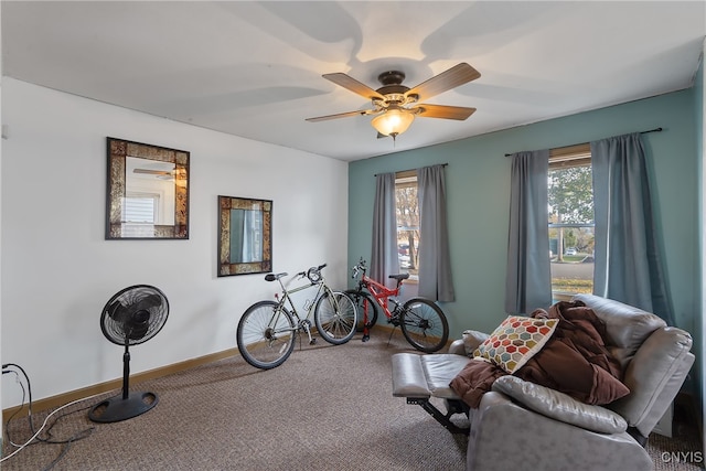 living area with carpet and ceiling fan