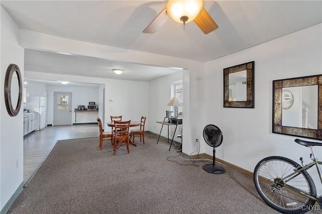 dining room with a ceiling fan, carpet floors, and baseboards