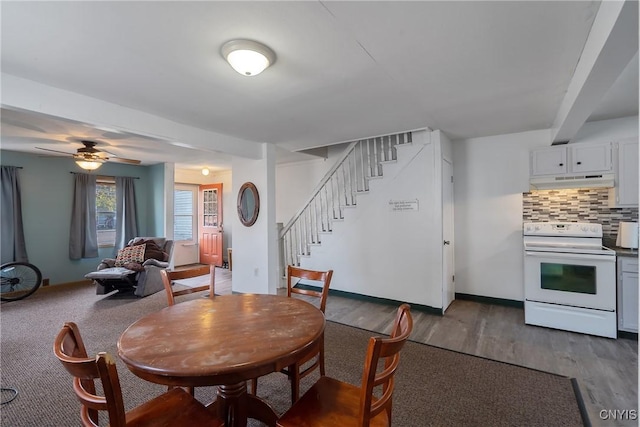 dining room featuring ceiling fan, dark wood-type flooring, stairway, and baseboards