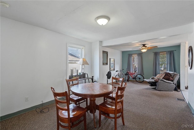 dining space featuring carpet floors, a wealth of natural light, visible vents, and baseboards