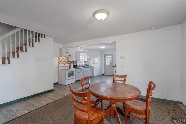 dining space with baseboards and stairs