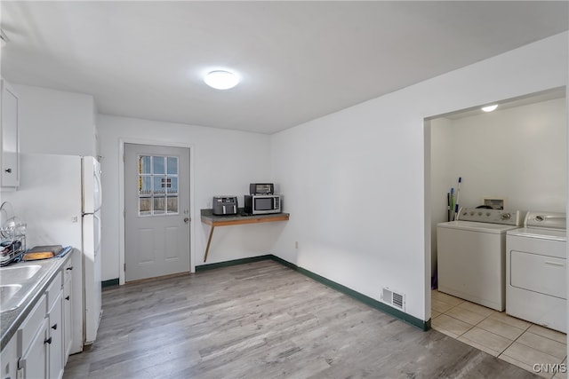 clothes washing area with light hardwood / wood-style flooring and separate washer and dryer