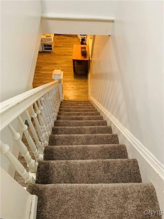 stairway with baseboards and wood finished floors