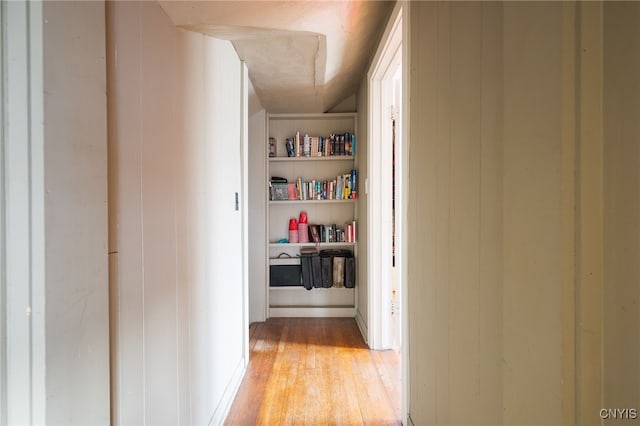 interior space with light hardwood / wood-style flooring and wood walls