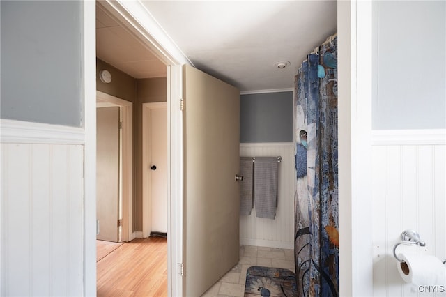 bathroom with crown molding and hardwood / wood-style flooring