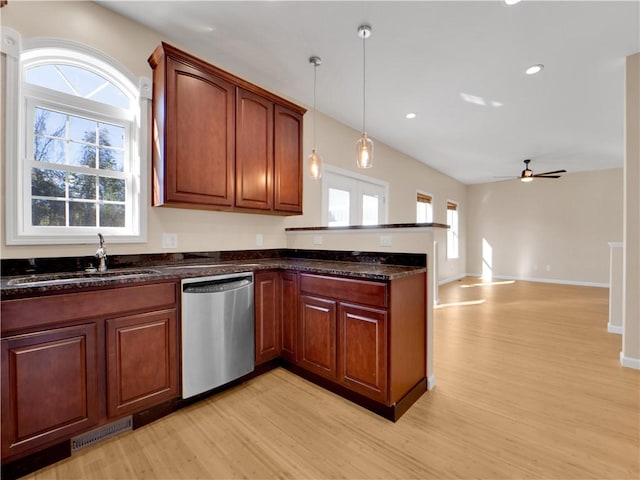 kitchen featuring pendant lighting, sink, dishwasher, light hardwood / wood-style floors, and dark stone counters