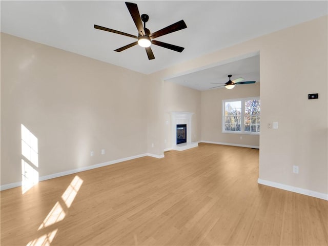 unfurnished living room featuring ceiling fan and light wood-type flooring