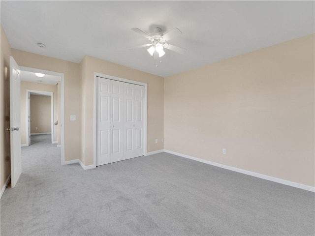 unfurnished bedroom with light carpet, ceiling fan, and a closet