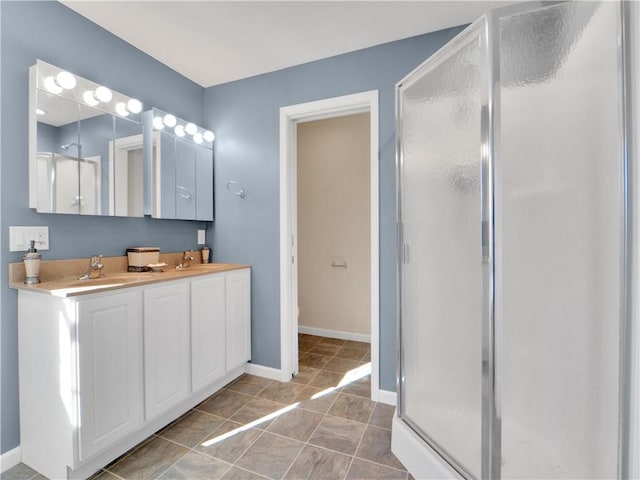 bathroom with tile patterned flooring, vanity, and walk in shower