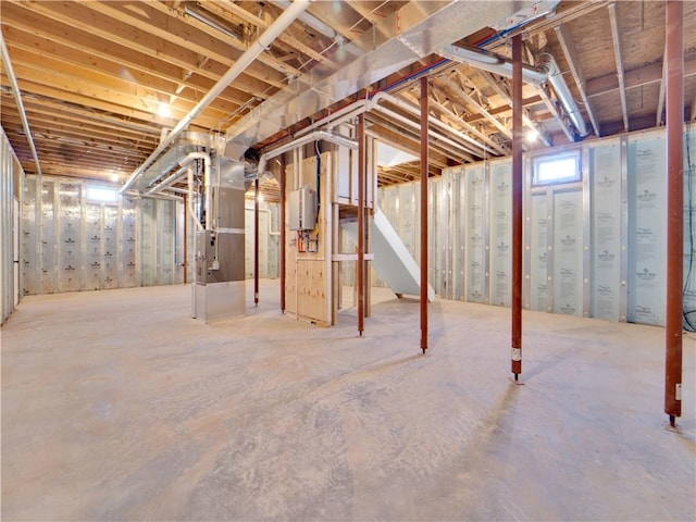 basement featuring water heater and heating unit