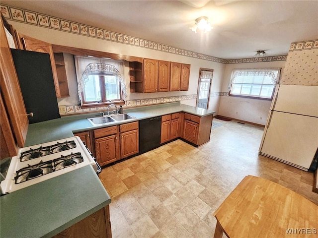 kitchen featuring white appliances, kitchen peninsula, sink, and a wealth of natural light