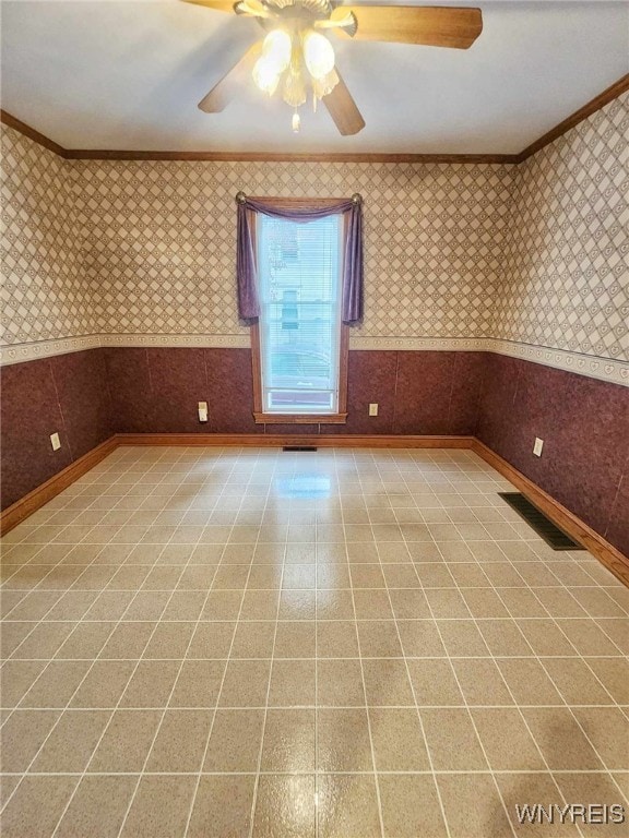 empty room featuring crown molding and ceiling fan