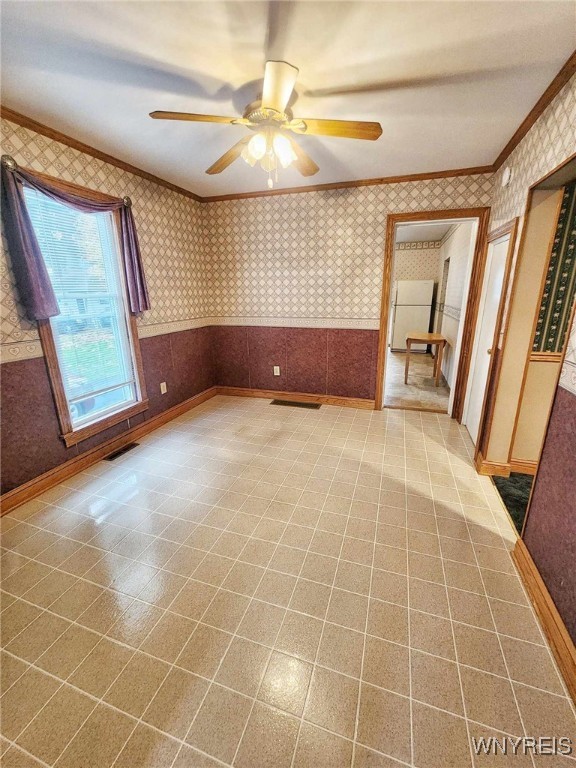 spare room with ornamental molding and ceiling fan