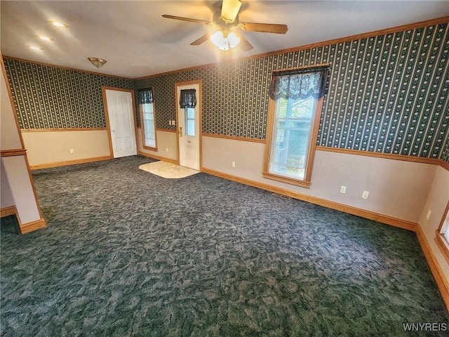 carpeted empty room with ceiling fan and crown molding