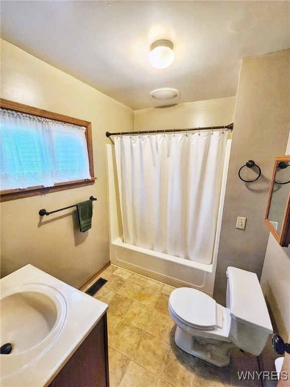 full bathroom with toilet, tile patterned flooring, vanity, and shower / tub combo