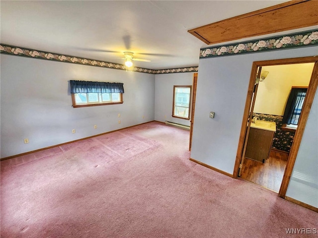 empty room with carpet floors, sink, a baseboard radiator, and ceiling fan