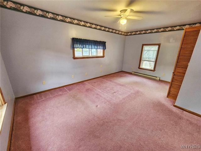 spare room featuring carpet, a baseboard heating unit, ceiling fan, and plenty of natural light