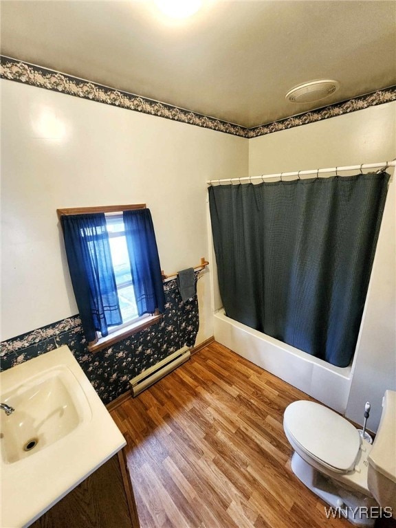 bathroom featuring curtained shower, hardwood / wood-style floors, toilet, baseboard heating, and vanity