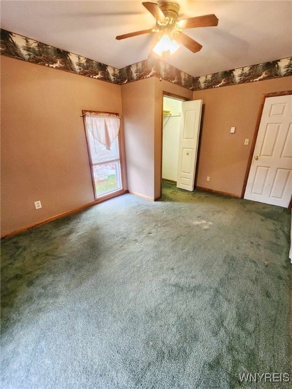 unfurnished room featuring dark carpet and ceiling fan