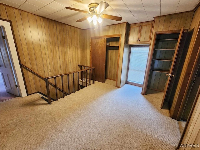 hall with light carpet and wood walls