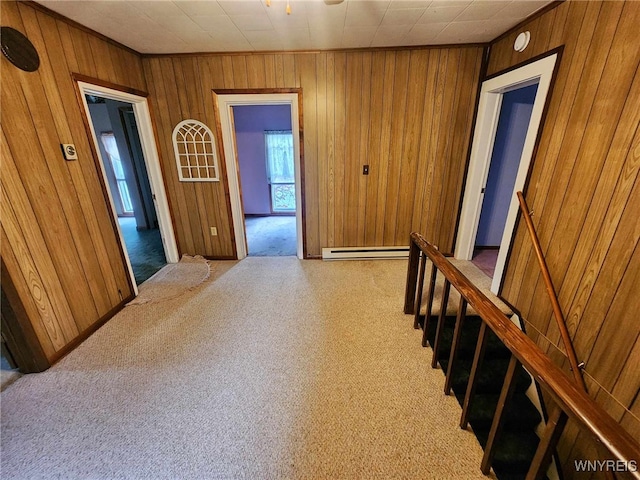 hall with light carpet, wood walls, and baseboard heating