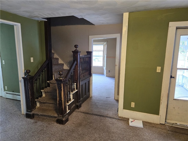 staircase featuring carpet and a baseboard heating unit