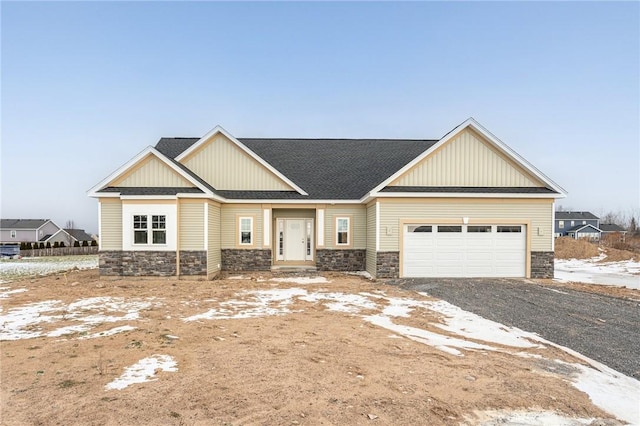 craftsman-style house featuring a garage, stone siding, board and batten siding, and driveway