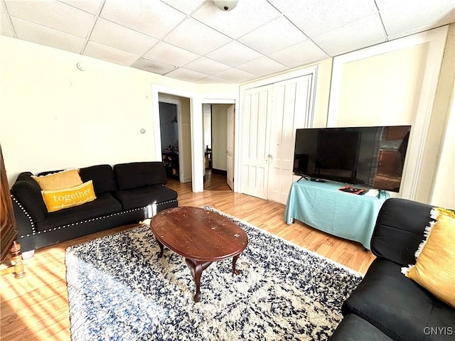 living area with wood finished floors and a drop ceiling
