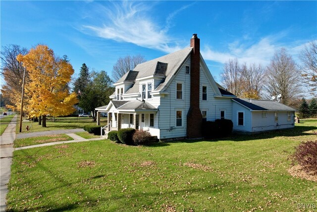 view of side of property featuring a yard and covered porch