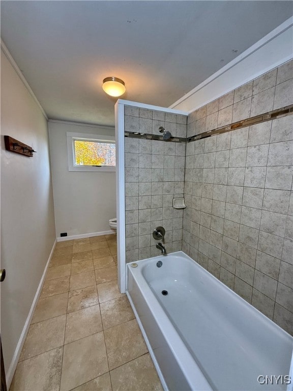 bathroom with tiled shower / bath, tile patterned floors, and toilet