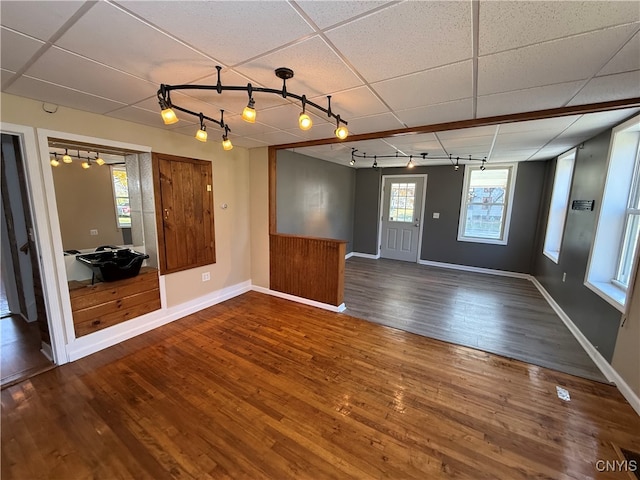 unfurnished room with track lighting, hardwood / wood-style flooring, and a paneled ceiling