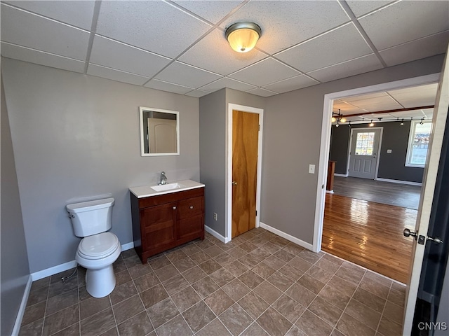 bathroom with vanity, hardwood / wood-style floors, toilet, and a paneled ceiling