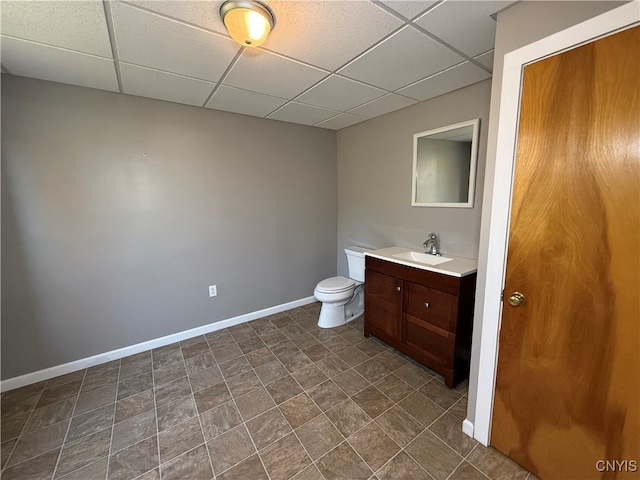 bathroom with vanity, a paneled ceiling, toilet, and tile patterned flooring