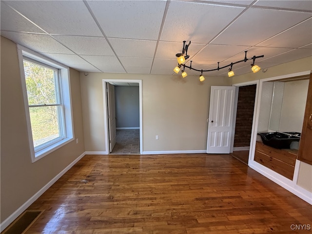 empty room with hardwood / wood-style flooring and a paneled ceiling