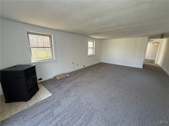 carpeted empty room with a wood stove