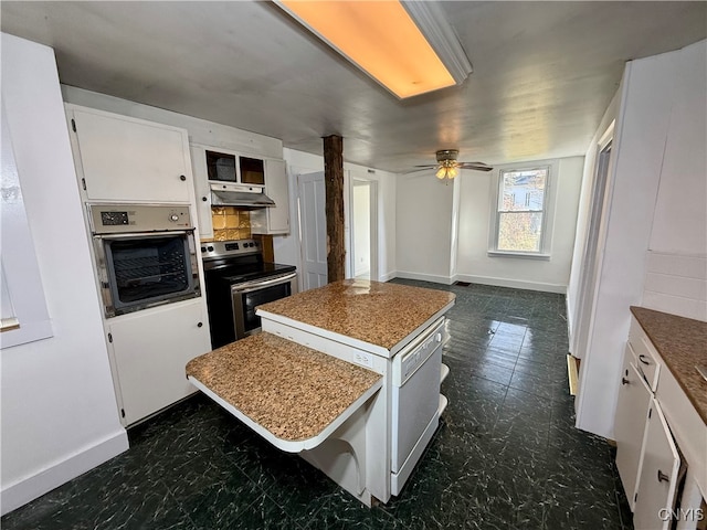 kitchen featuring ceiling fan, white cabinetry, a kitchen bar, stainless steel appliances, and a center island