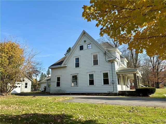 view of side of home featuring a yard and a porch