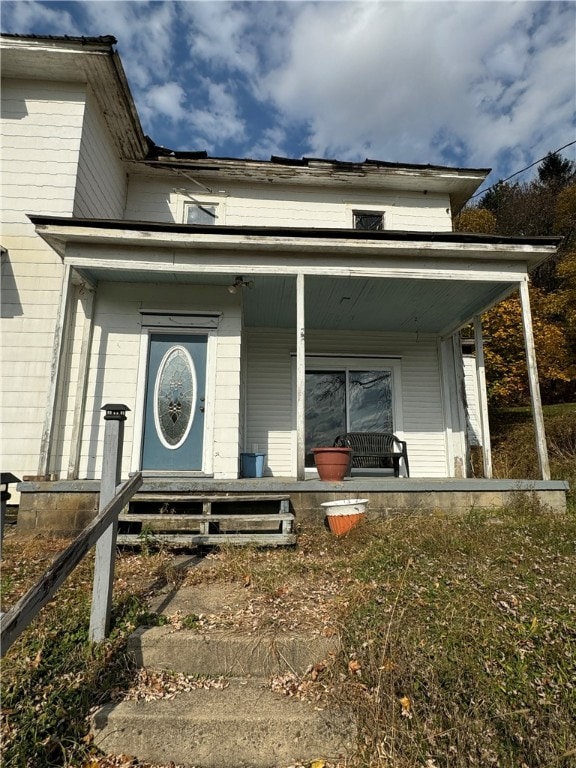 view of exterior entry featuring covered porch