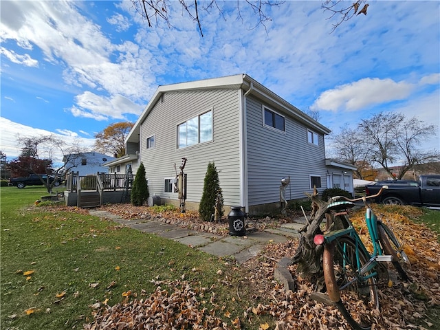 view of side of property with a wooden deck and a yard