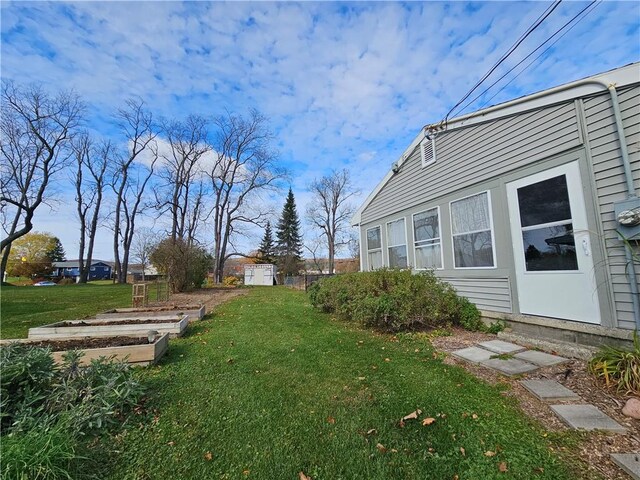 42 Pine Cir, Big Flats, NY 14845 - view of grassy yard featuring a vegetable garden, a shed, and an outdoor structure