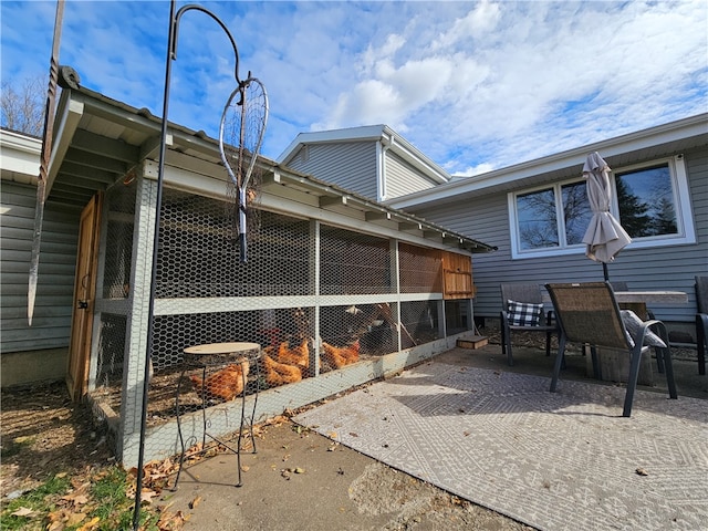 view of property exterior with a patio area and a sunroom