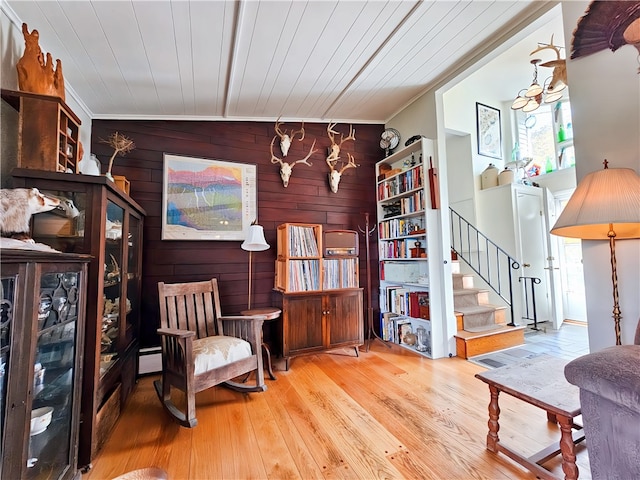 living area featuring hardwood / wood-style flooring, wooden ceiling, ornamental molding, and wooden walls