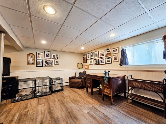 living area with hardwood / wood-style floors and a paneled ceiling