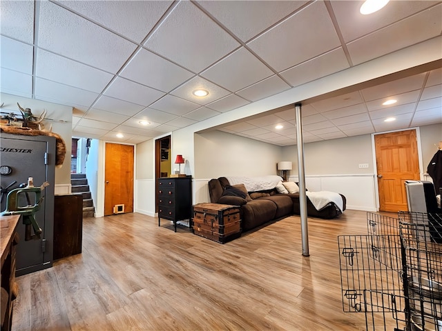 living room with hardwood / wood-style flooring and a drop ceiling