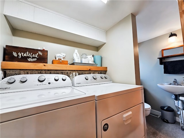 laundry room with sink, separate washer and dryer, and dark carpet