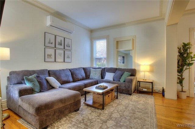 living room featuring a wall unit AC, hardwood / wood-style flooring, and crown molding