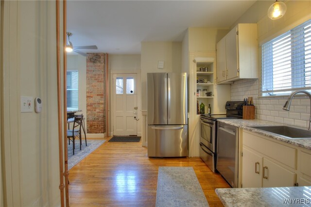 kitchen with light hardwood / wood-style flooring, sink, white cabinets, appliances with stainless steel finishes, and ceiling fan