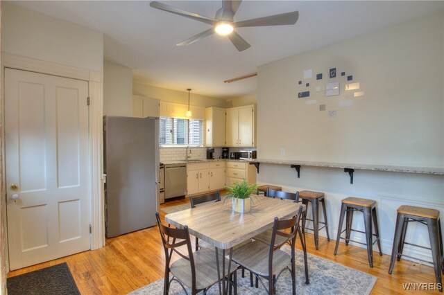 dining space featuring sink, light hardwood / wood-style flooring, and ceiling fan