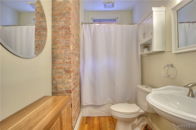 full bathroom with sink, shower / bath combo, wood-type flooring, and toilet